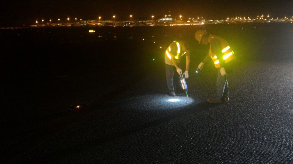 Maintenance workers repair the taxiway with Roadware Flexible Cement II.